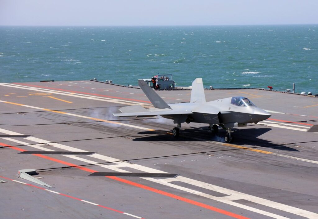 J-35 stealth fighter jet touching down on the deck of the Fujian aircraft carrier using arrester cables.